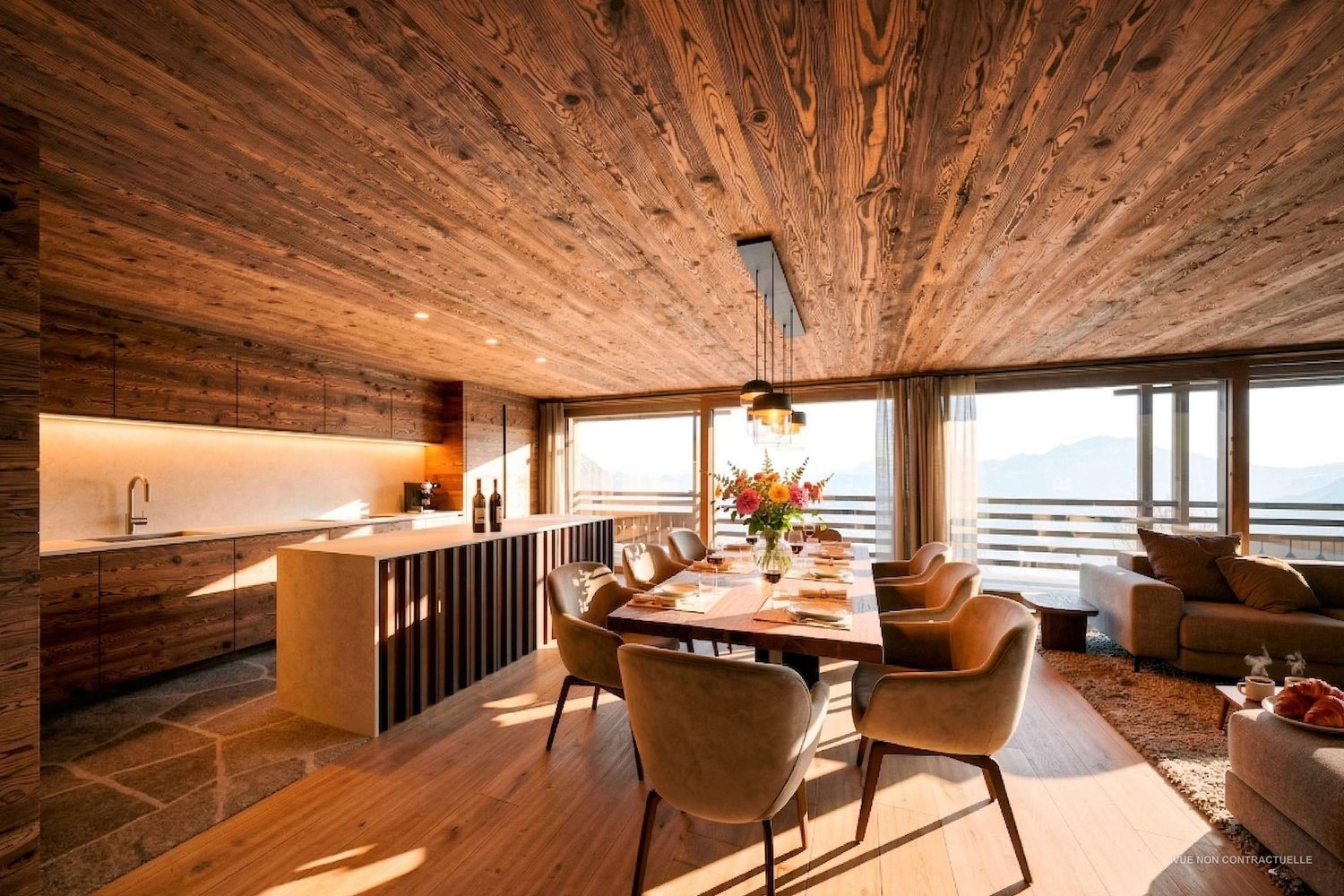 Cuisine du duplex des combles : îlot central habillé de bois, plafond en vieux bois, vue sur les sommets.